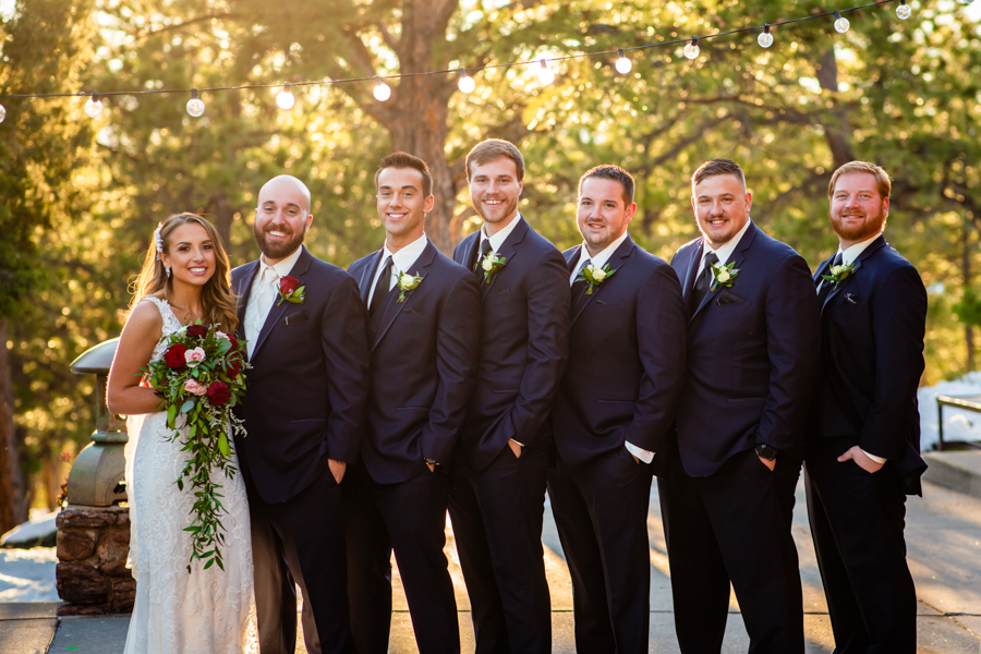 bride and groom standing next to 5 groomsmen in the mountains