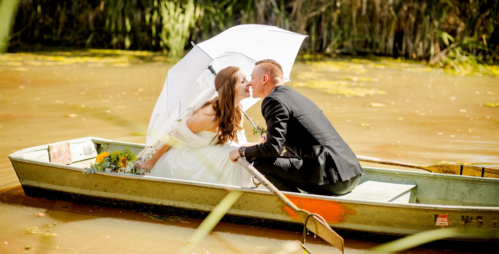 wedding couple kissing on a small boat