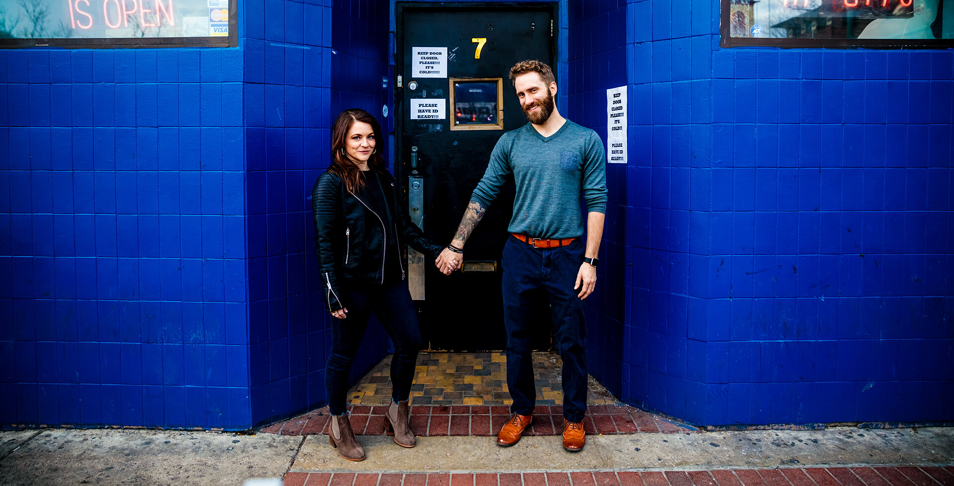 engaged couple posing in front of Hi-Dive in Denver